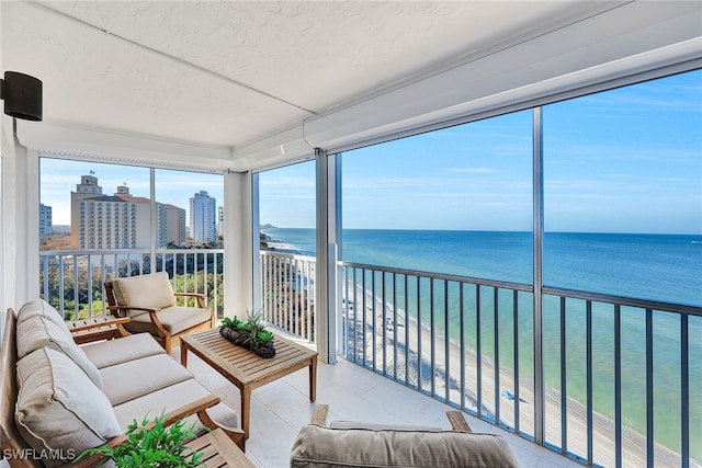 sunroom featuring a water view