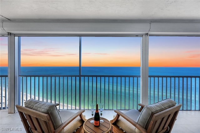 sunroom with a water view and a beach view