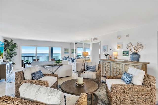 living room with light tile patterned floors and a water view