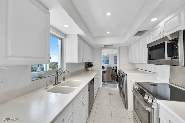 kitchen with sink, white cabinetry, stainless steel appliances, and light tile patterned floors