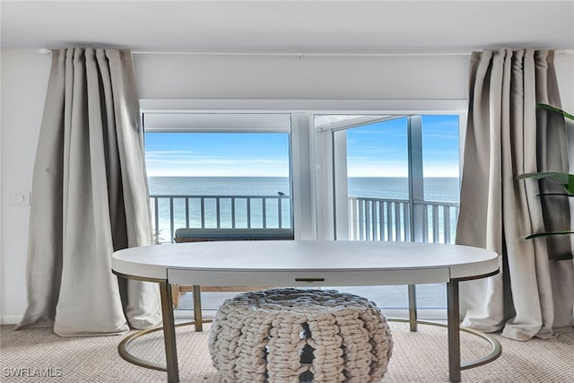 carpeted dining room featuring a water view