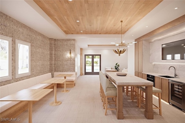 dining area featuring french doors, sink, beverage cooler, wood ceiling, and tile walls