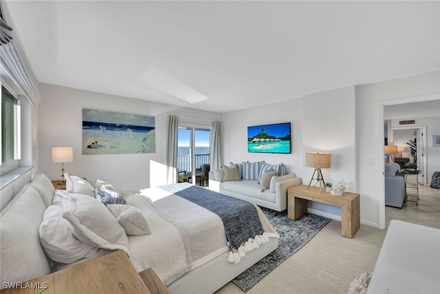 bedroom featuring light colored carpet and multiple windows