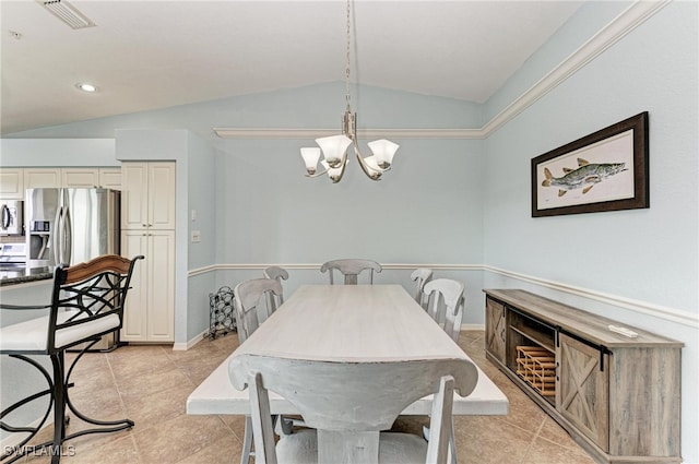 tiled dining room with a chandelier and vaulted ceiling