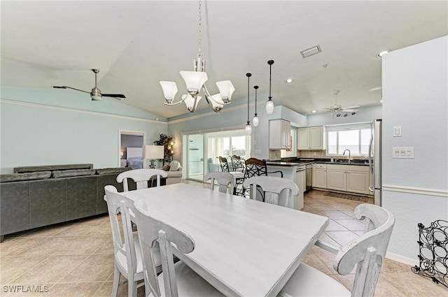 tiled dining room featuring sink, vaulted ceiling, and ceiling fan with notable chandelier