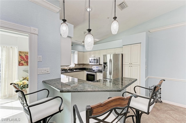 kitchen with vaulted ceiling, decorative light fixtures, stainless steel appliances, and kitchen peninsula