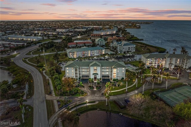 aerial view at dusk featuring a water view