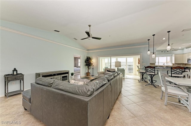 tiled living room featuring lofted ceiling, sink, and ceiling fan