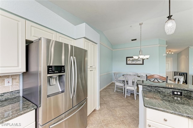 kitchen featuring lofted ceiling, stainless steel fridge, decorative backsplash, and pendant lighting