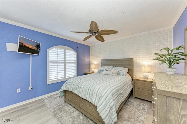 bedroom with light hardwood / wood-style floors, ornamental molding, and ceiling fan