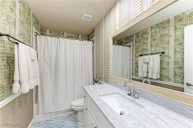 bathroom with vanity, toilet, a textured ceiling, and walk in shower