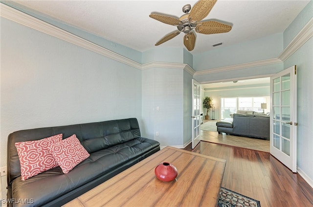 living room featuring french doors, ornamental molding, wood-type flooring, and ceiling fan