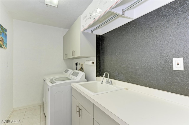 washroom featuring cabinets, sink, separate washer and dryer, and light tile patterned floors