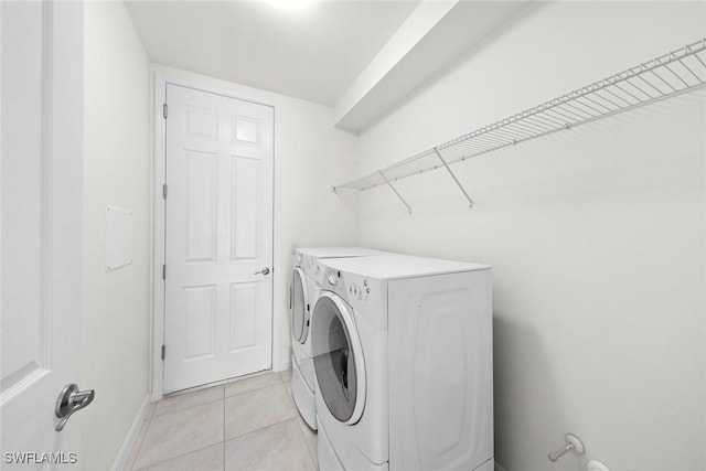 laundry room with separate washer and dryer and light tile patterned flooring