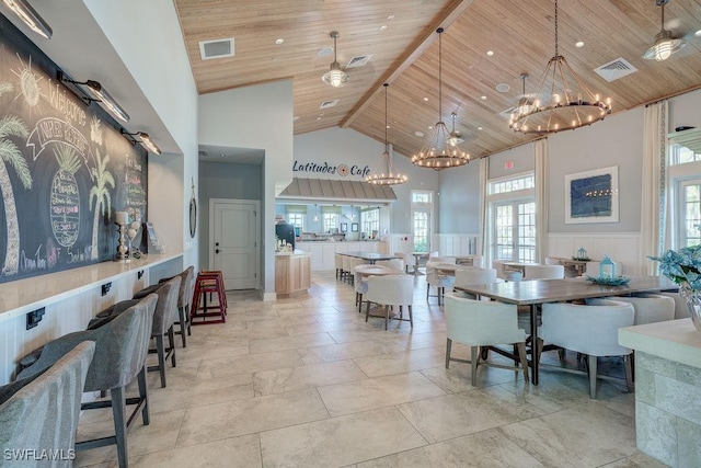 dining area featuring a wealth of natural light, wood ceiling, and a high ceiling