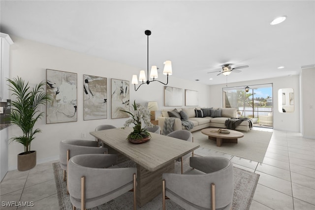 tiled dining area featuring ceiling fan with notable chandelier