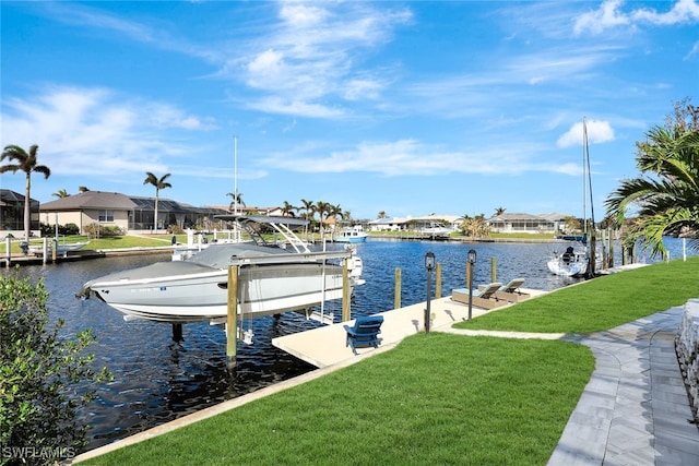 view of dock with a yard and a water view