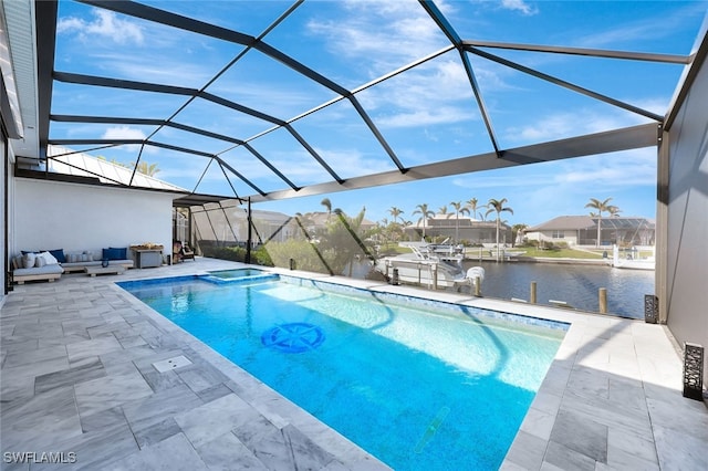 view of pool with glass enclosure, a patio area, and a water view