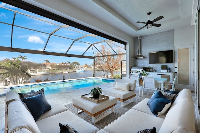 view of pool with an outdoor living space, glass enclosure, ceiling fan, a grill, and a patio area