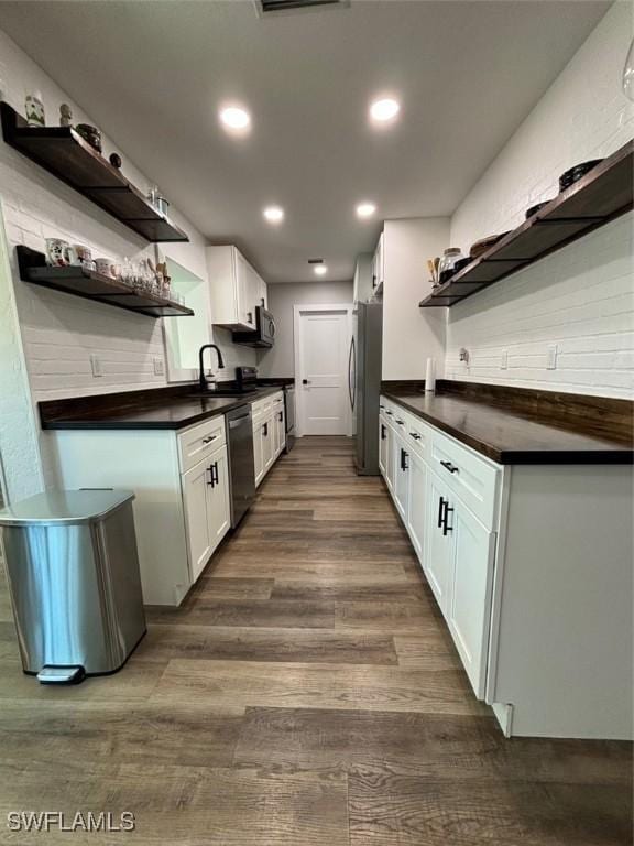 kitchen featuring appliances with stainless steel finishes, sink, white cabinetry, and dark hardwood / wood-style floors