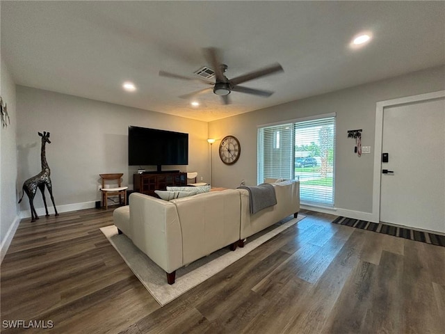 living room featuring ceiling fan and dark hardwood / wood-style flooring