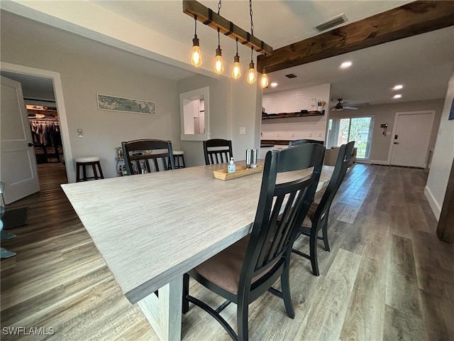 dining room featuring ceiling fan, dark hardwood / wood-style floors, and beamed ceiling