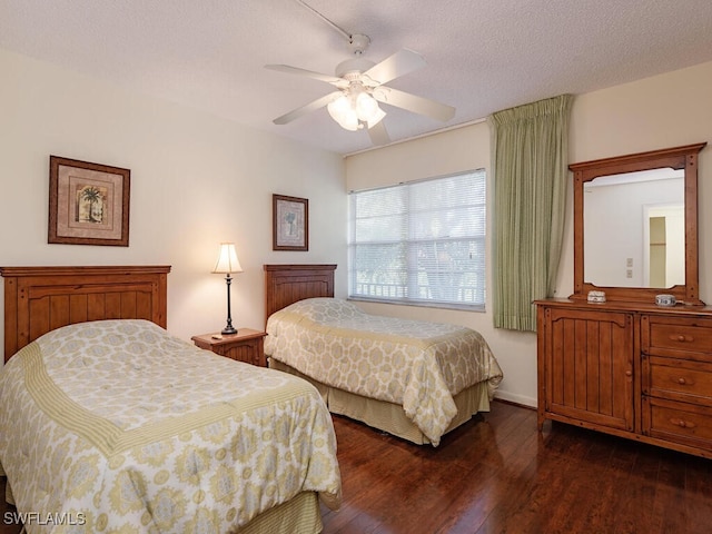 bedroom featuring dark hardwood / wood-style floors, a textured ceiling, and ceiling fan