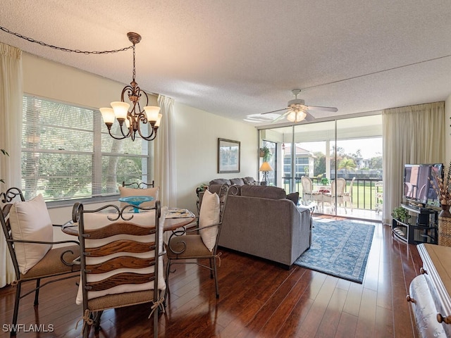 dining space featuring dark wood-type flooring, a textured ceiling, and ceiling fan with notable chandelier