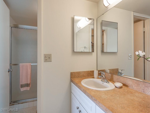 bathroom with vanity and a shower with shower door