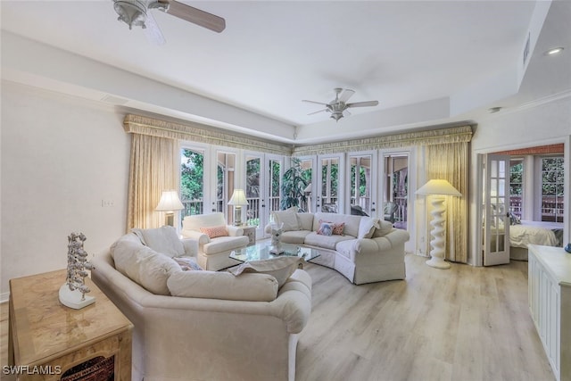 living room with light wood-type flooring, a wealth of natural light, french doors, and ceiling fan