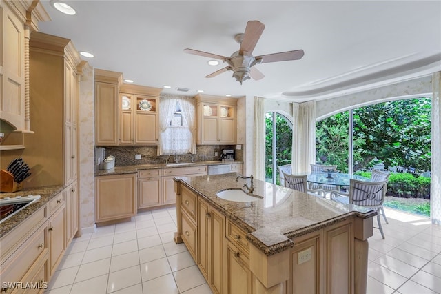 kitchen with a center island with sink, sink, and light tile patterned floors