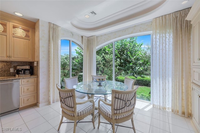 tiled dining room with a tray ceiling