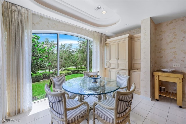 tiled dining space with a raised ceiling