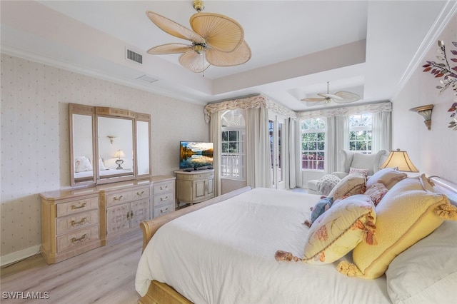 bedroom featuring ceiling fan, a raised ceiling, light hardwood / wood-style flooring, crown molding, and access to outside