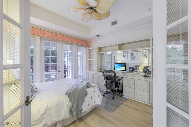 bedroom featuring multiple windows, french doors, built in desk, and ceiling fan