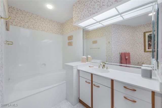 bathroom featuring a washtub and vanity