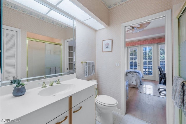 bathroom with wood-type flooring, toilet, an enclosed shower, vanity, and ceiling fan