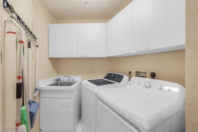 laundry room featuring cabinets, sink, and separate washer and dryer