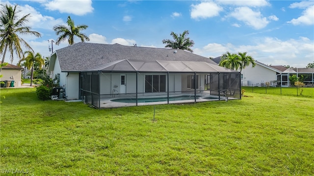 rear view of property featuring a yard, a patio area, and a lanai