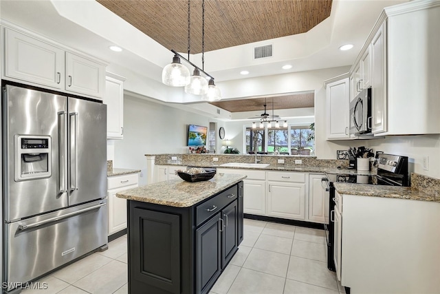 kitchen featuring white cabinetry, a center island, a raised ceiling, and stainless steel appliances