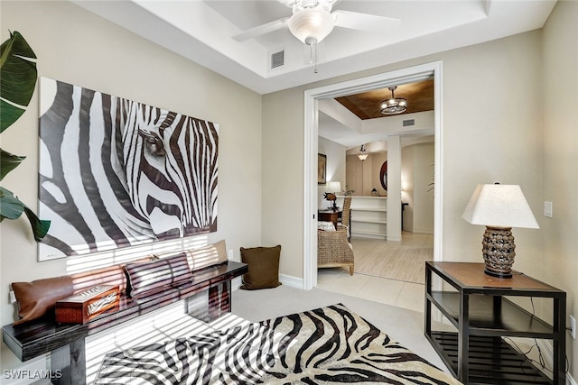 interior space featuring ceiling fan and a raised ceiling