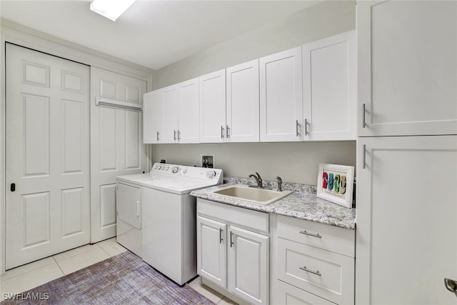 clothes washing area with cabinets, light tile patterned floors, sink, and independent washer and dryer