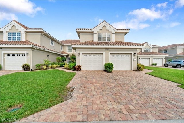 mediterranean / spanish home with a front yard and a garage