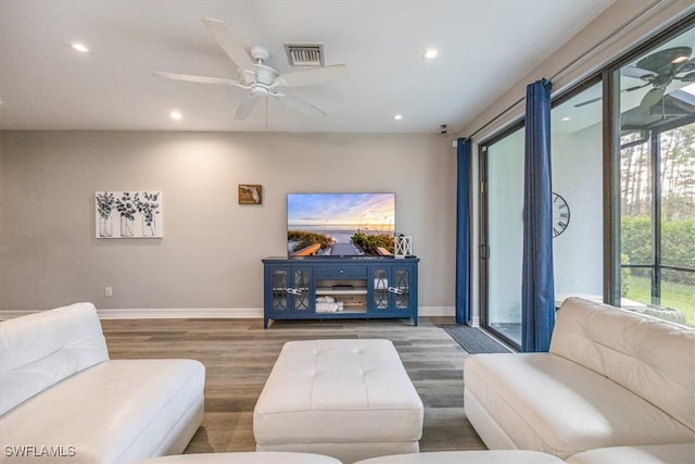 living room with wood-type flooring, ceiling fan, and plenty of natural light