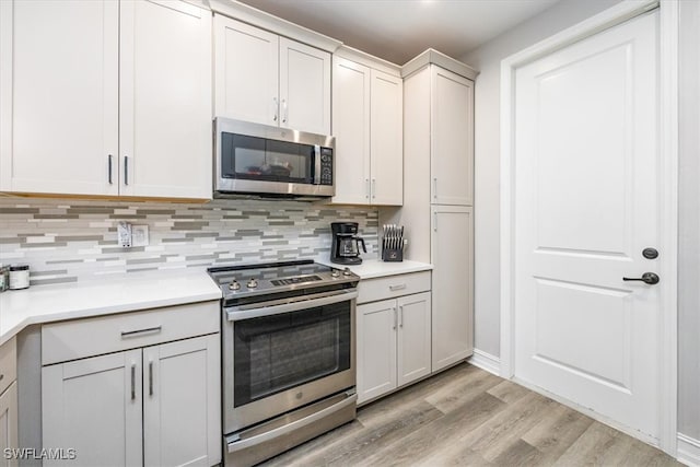 kitchen featuring decorative backsplash, appliances with stainless steel finishes, and light hardwood / wood-style flooring