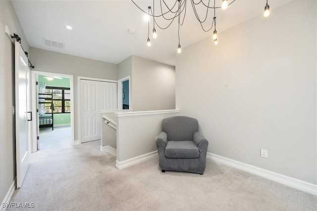 living area with light colored carpet, a notable chandelier, and a barn door