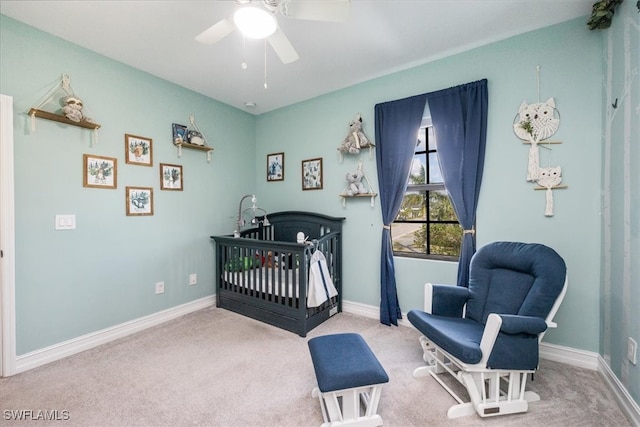 carpeted bedroom with a nursery area and ceiling fan