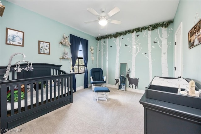 bedroom with carpet, ceiling fan, and a crib