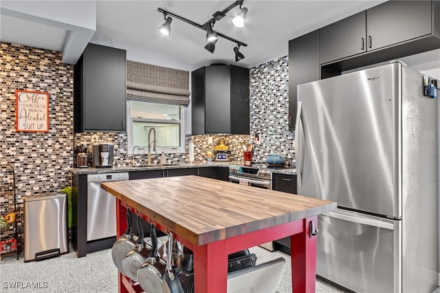 kitchen with tasteful backsplash, sink, stainless steel appliances, and wooden counters