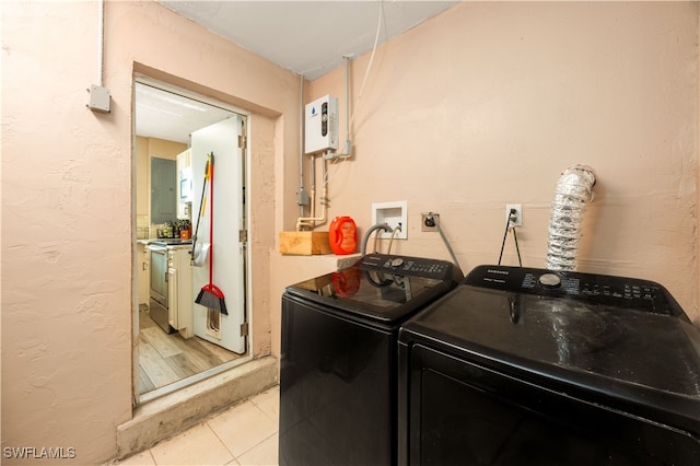 laundry room featuring light tile patterned floors and washing machine and clothes dryer